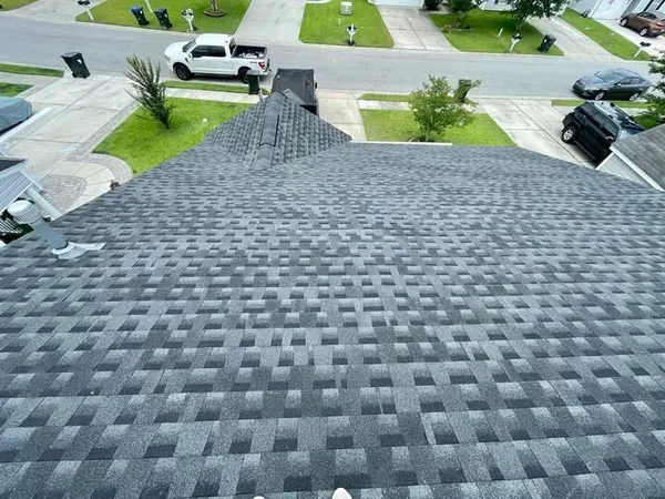 Aerial view of a completed gray shingle roof over a residential street